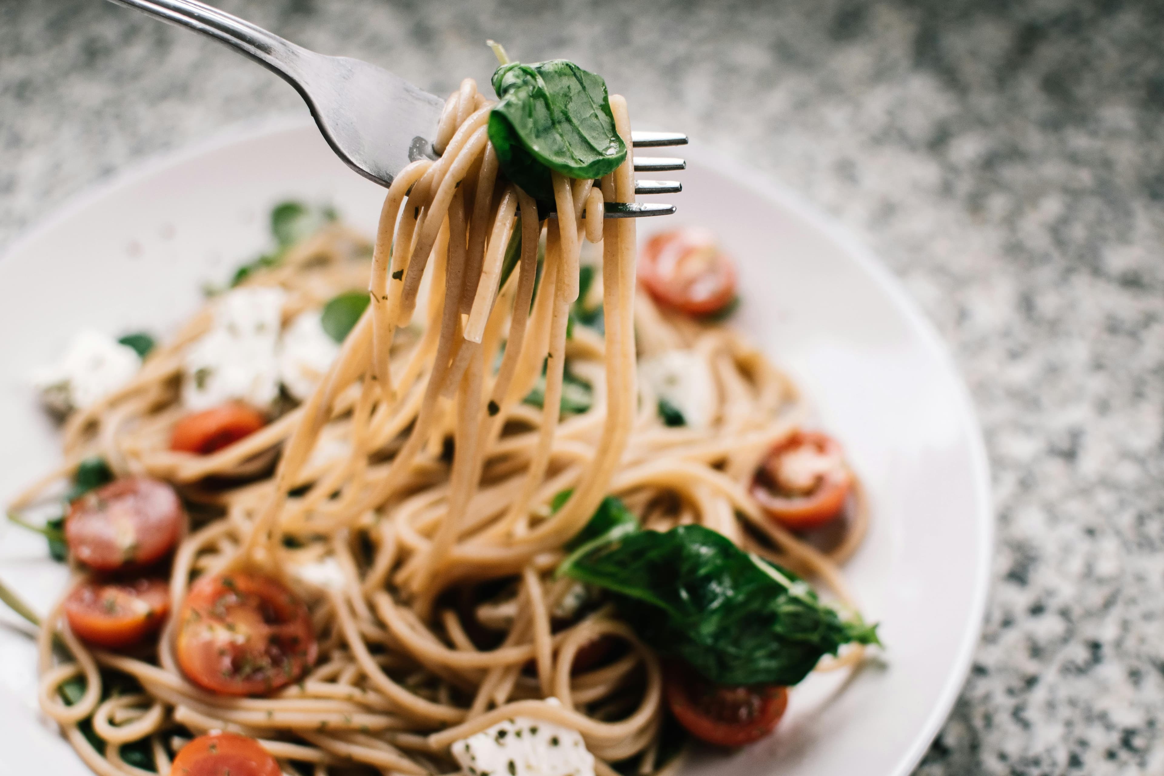 Bowl of spaghetti with tomato sauce and garnished with herbs
